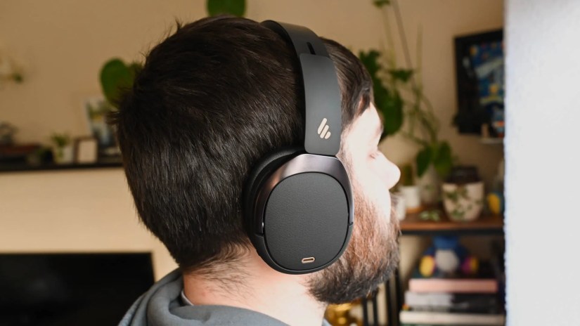 A person wearing the edifier WH950NB headphones