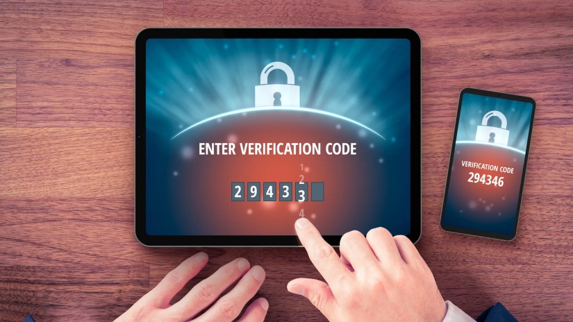 A person types in a two-factor authentication security code into a tablet.