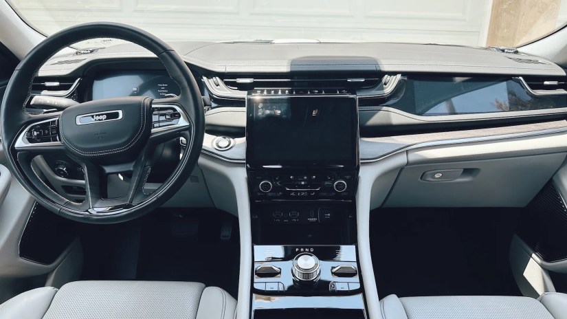 A view of the car&rsquo;s dashboard, screen, and steering wheel
