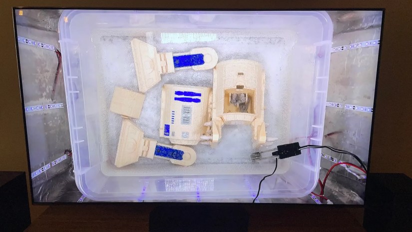 A disassembled R2D2 toy on the Samsung 55-inch QN90C.
