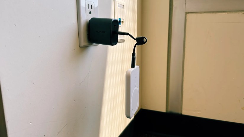 Showing Nomad ChargeKey plugged into a wall adapter with a battery hanging above the ground