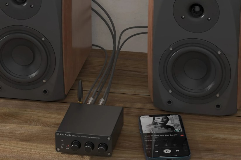 The Fosi Audio BT20A in front of speakers.