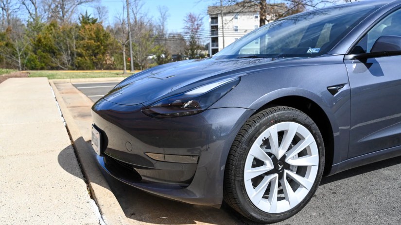 Front end, wheel, and tire of a Tesla Model 3.