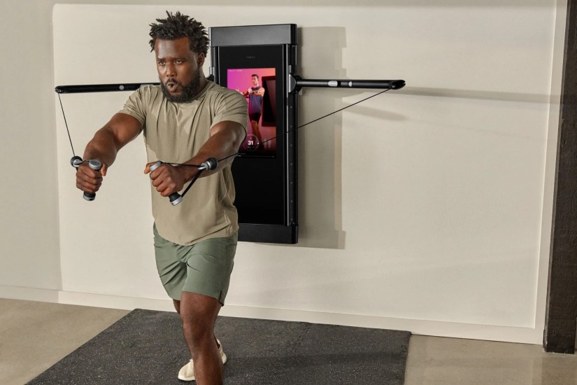 man using tonal exercise equipment