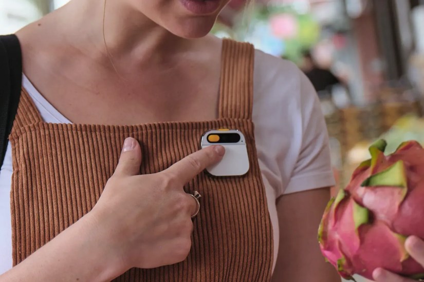 A woman wearing the Humane Ai Pin.