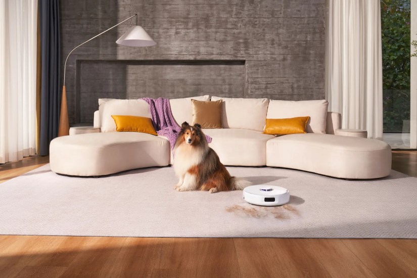 A Dog Sitting in Front of a Couch with the Narwal Freo X Ultra Next to It