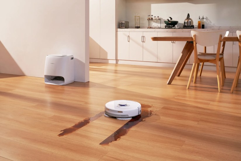 The Narwal Freo X Ultra Cleaning a Stain in Front of its All-in-one Station