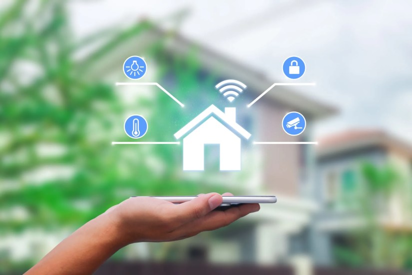 Hands holding smart phone with app smart home on blurred house as backgrounds.