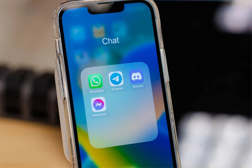 The WhatsApp app visible on a phone with several other messaging apps.