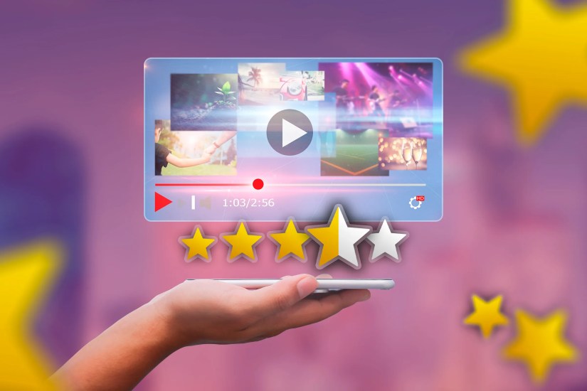 A hand holding a phone with a video player and some rating stars above the screen