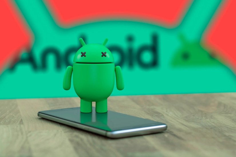 Android mascot on top of a phone with &lsquo;X&rsquo; eyes indicating that it is dead, and the Android logo in the background.