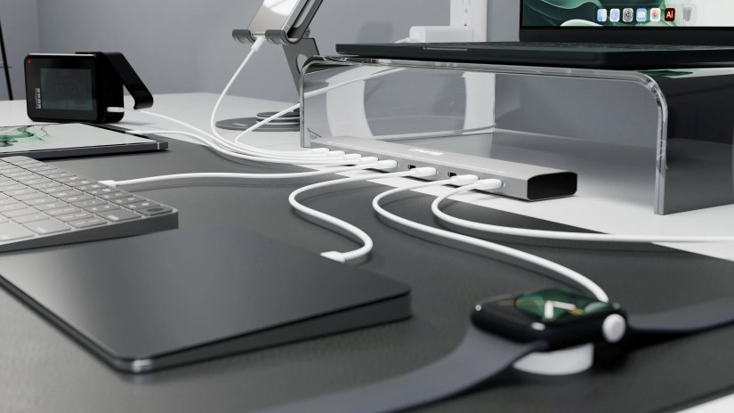Plugable&rsquo;s multi-port charging station with Apple Watch, iPhone, laptop, and other devices plugged into it.