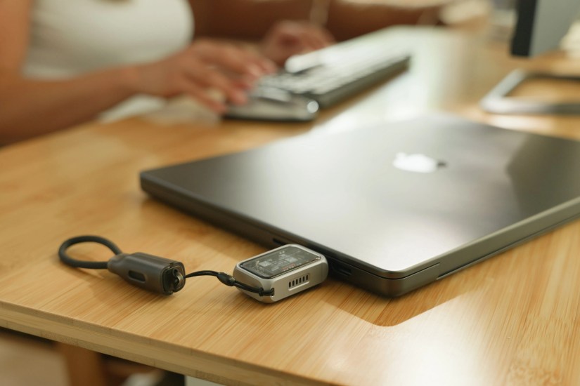 Satechi&rsquo;s SSD enclosure plugged into a MacBook Pro lying on a wooden desk.