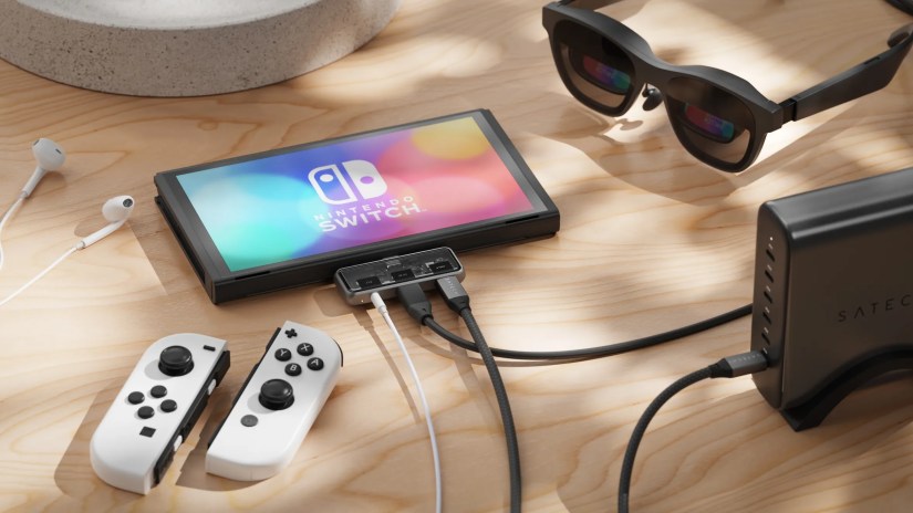 Satechi&rsquo;s mobile hub plugged into a Nintendo Switch console lying on a wooden desk.