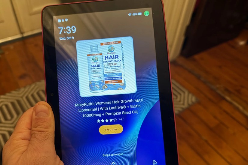 An Amazon Fire HD 8 in a hand, showing an  for MaryRuth&rsquo;s Hair Growth formula.