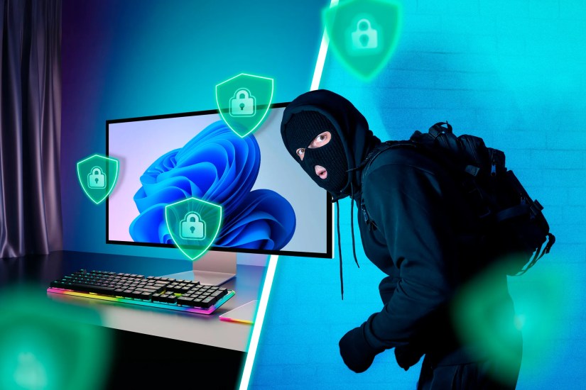 A Windows desktop on the left with several security shields around it and a thief on the right.