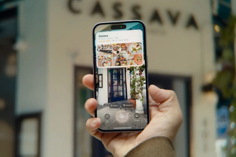 iPhone held in hand, with visual intelligence used to lookup a restaurant in the camera viewfinder.