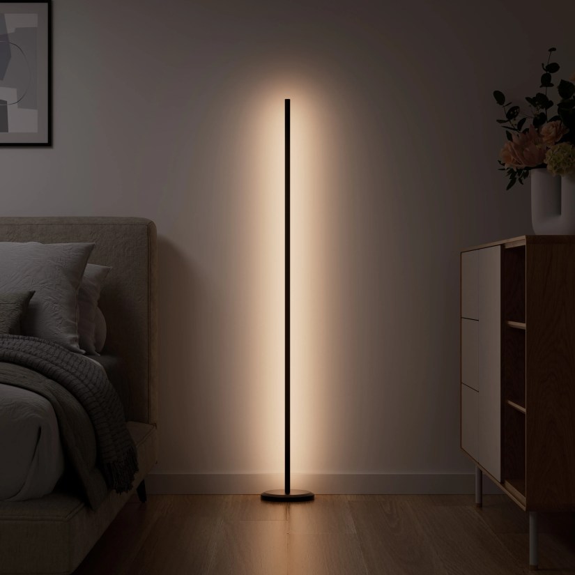 Nanoleaf&rsquo;s floor lamp in a bedroom, emitting a white ambient light.