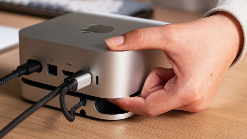 Hand reaching for the power button on Satechi&rsquo;s Mac Mini hub.