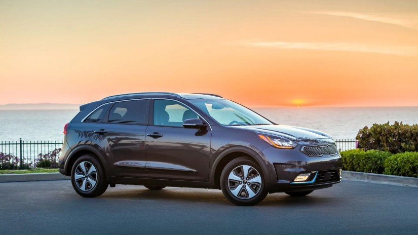 Full view of gray 2018 Kia Niro Plug-In Hybrid parked on tarmac as the sun sets.