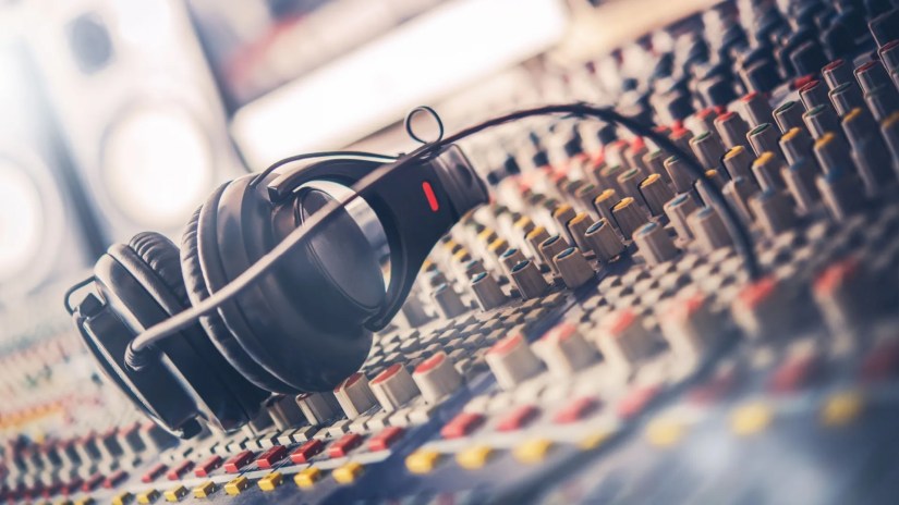 Mixer and professional headphones in the recording studio. Sound mixing desk. Sound mastering for radio and tv broadcast.