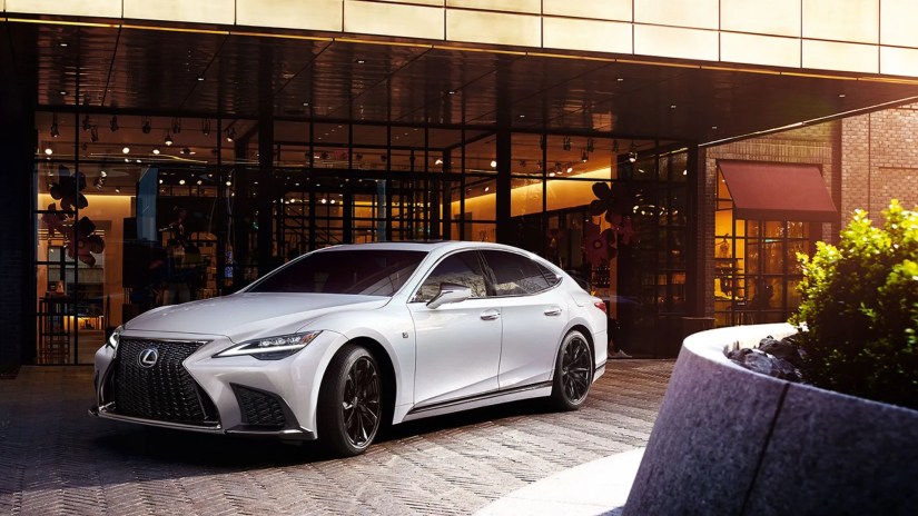 Front 3/4 view of a white 2025 Lexus LS parked outside of a building.