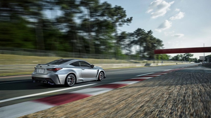 Rear 3/4 view of a silver 2025 Lexus RC F Final Edition on a racetrack.