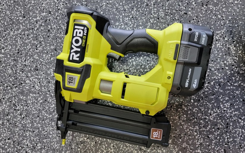 Ryobi brad nailer on a garage floor.