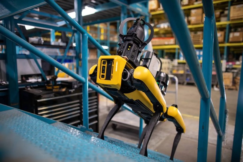Spot robot climbing stairs in a warehouse.