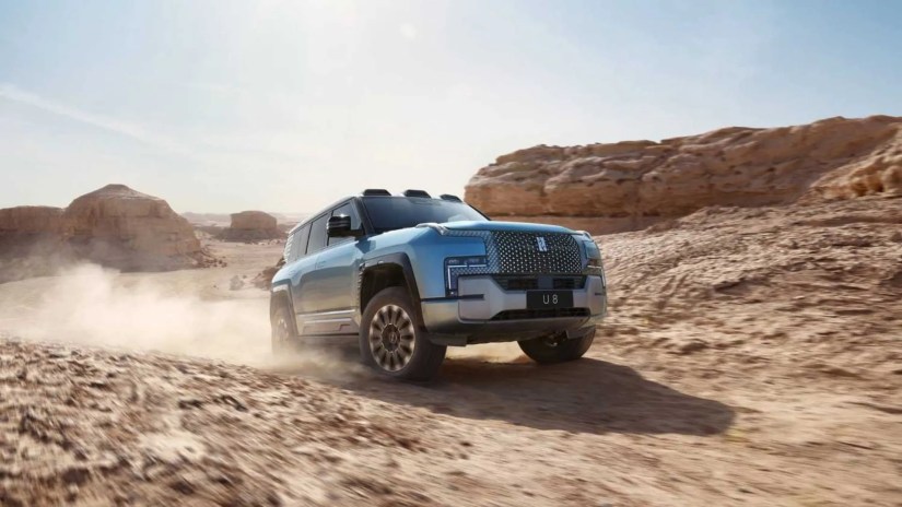 Front 3/4 view of a silver Yangwang U8 off-roading in the desert.