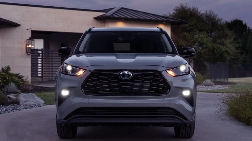 Front end shot of a gray 2024 Toyota Highlander parked on the driveway of a home.