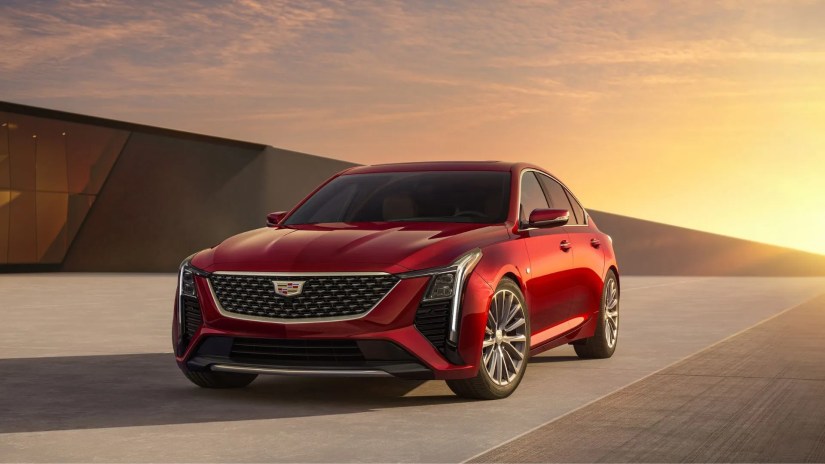 Front 3/4 shot of a red 2025 Cadillac CT5 with the sun setting in the background.