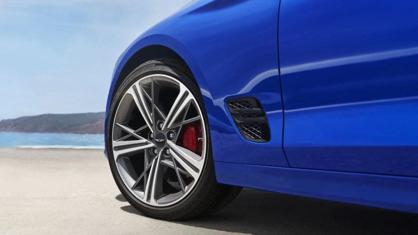 Close-up shot of the alloy wheel of a blue 2025 Genesis G70.