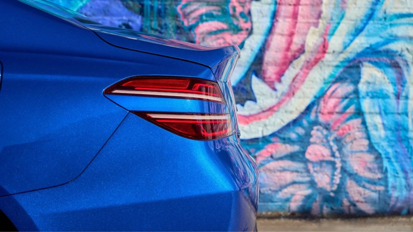 Close-up shot of the trunk and rear taillight of a blue 2025 Genesis G70.
