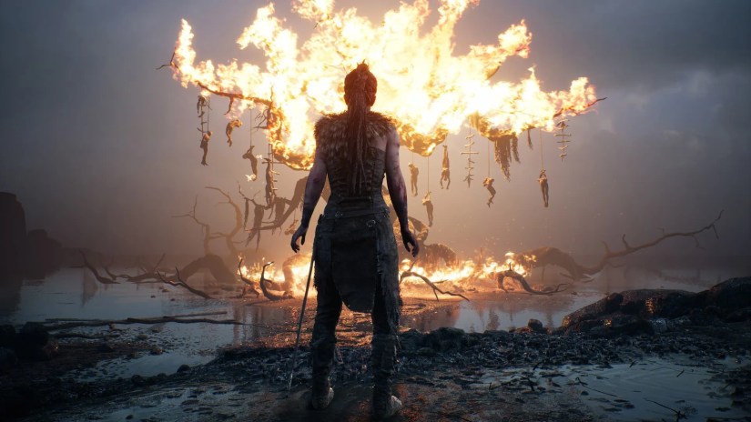 Senua looks at a burning tree in Hellblade: Senua&rsquo;s Sacrifice.