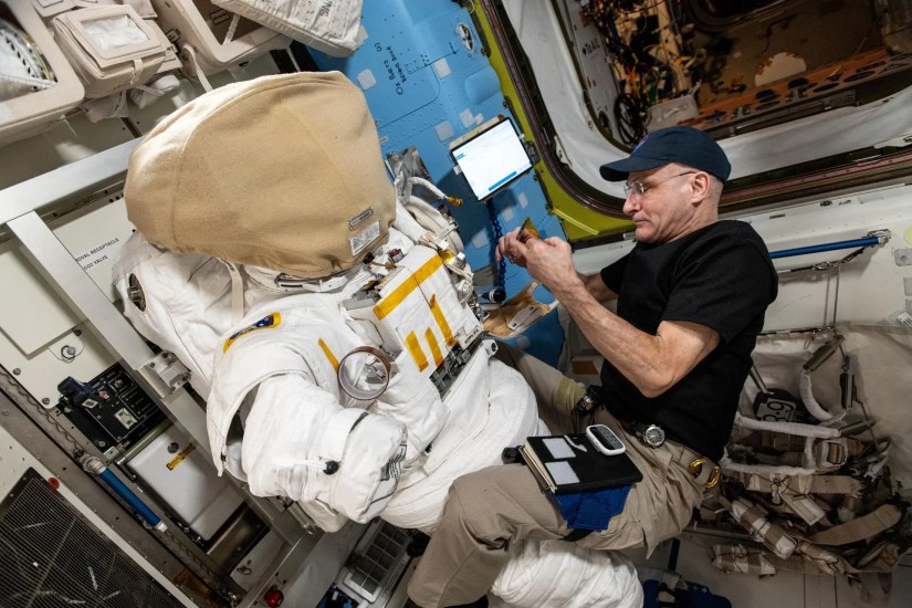 Astronaut Don Pettit inspects a spacesuit aboard the International Space Station’s Quest airlock.