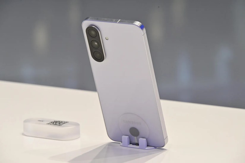 Samsung Galaxy A56 put on a stand showing its camera system and glass back
