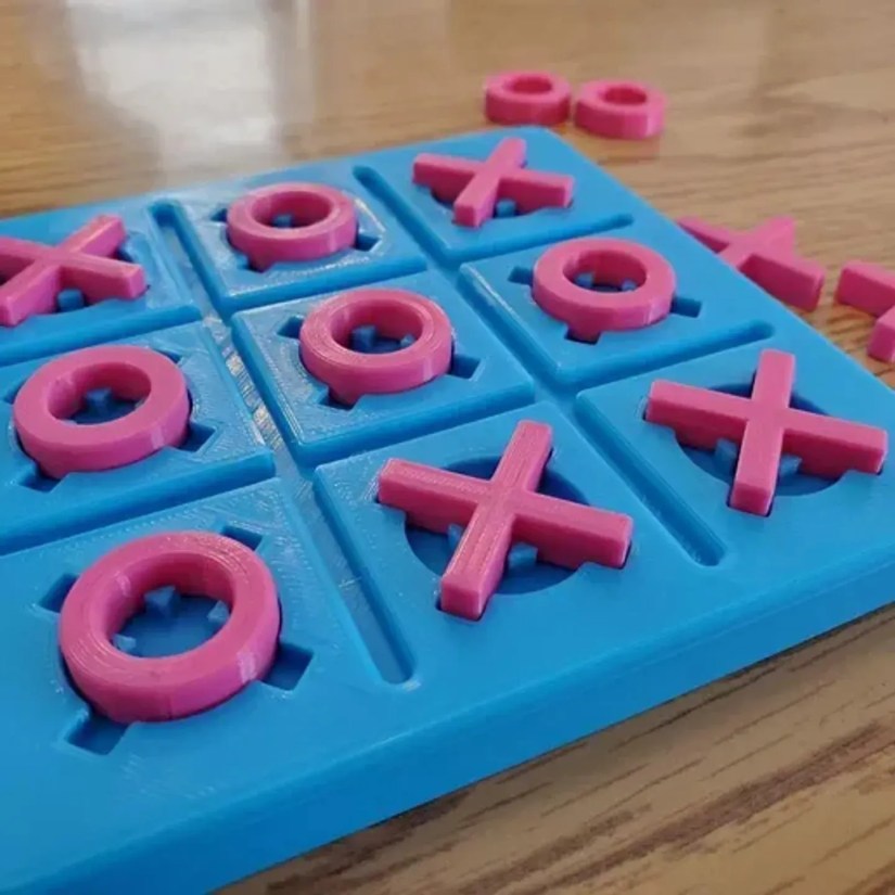 A 3D printed tic-tac-toe game with a blue board and pink pieces.