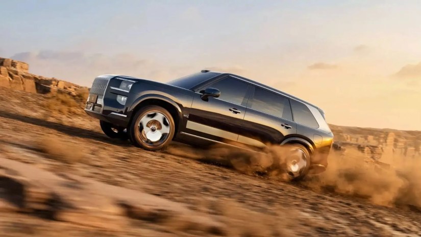 Side profile shot of the all-new Zeekr 9X off-roading in the desert.