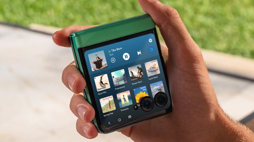 Image of the Moto Razr 2025 in its green variant held in hand with the screen showing upfront.