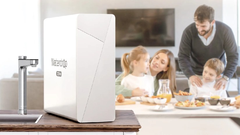 A family of four eats breakfast with a water filter in the foreground.