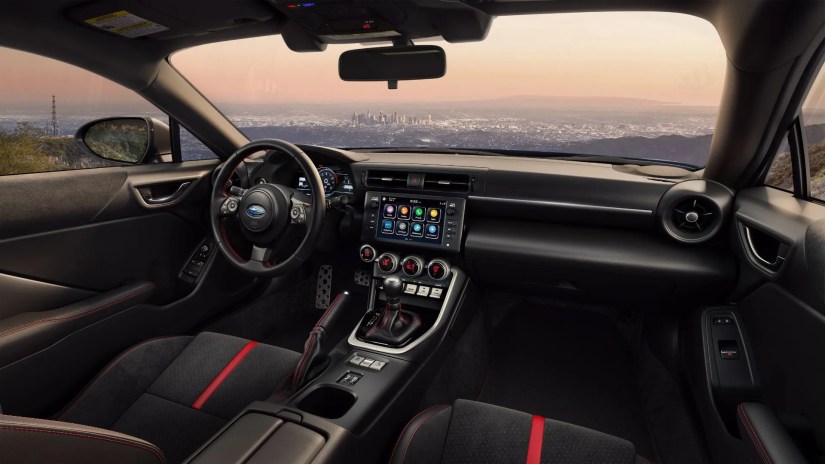 Shot of inside the cabin of a 2024 Subaru BRZ, showing the front setas, steering wheel, infotainment screen, and center console.