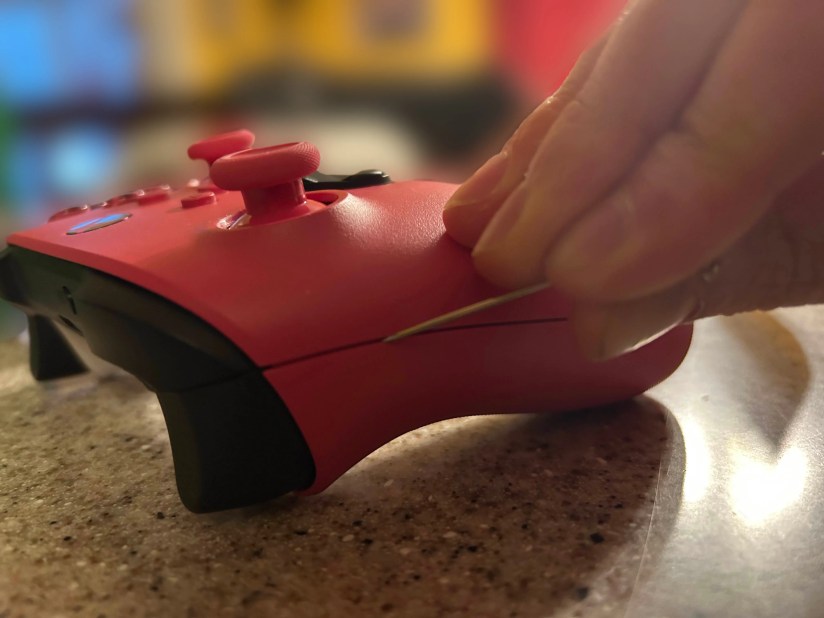 A Metal Pick running down the seam of a Pink Xbox One Controller.