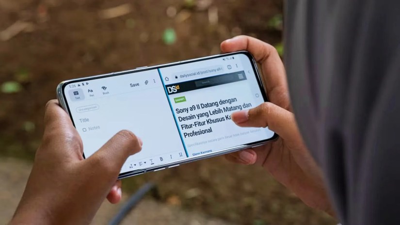 Person&rsquo;s hands holding an Android phone and using it in split-screen mode.