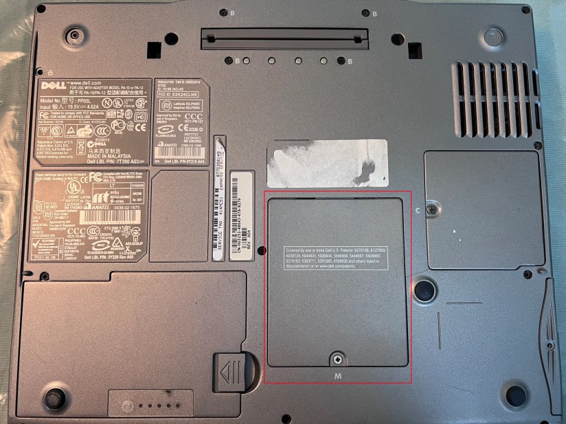 A screenshot of the bottom of a Dell laptop with the RAM access cover highlighted in red.