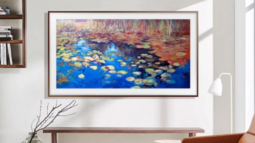 A Samsung the Frame TV on a wall over a table.