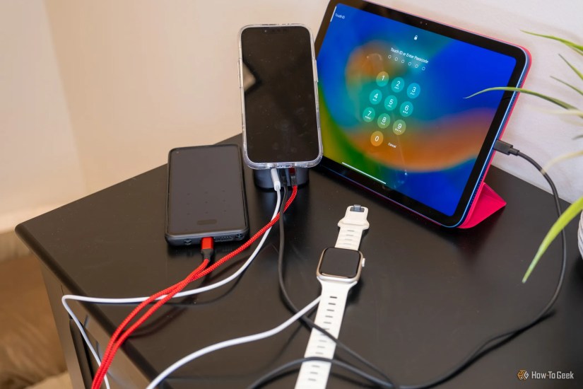 The Ugreen 100W 2-in-1 GaN Charging Station charging a watch, phone, iPad, and battery pack