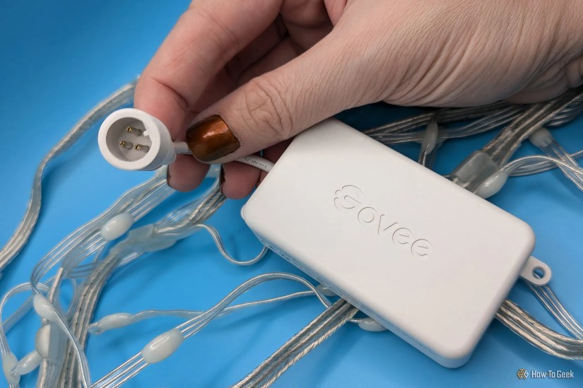 A hand holding the Govee Icicle Lights waterproof power connector.