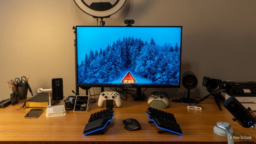 The GIGABYTE M32U 32-inch 4K monitor on a desk with peripherals around it.