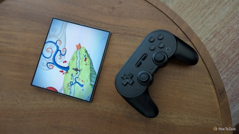 &lsquo;Figment&rsquo; on the Galaxy Z Fold 6 next to an 8BitDo Pro 2 Bluetooth controller.